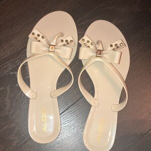 Cream Aldo thongs with studs and bow